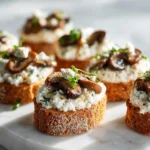 Close-up of roasted mushroom ricotta canapés on toasted bread with creamy cheese and caramelized mushrooms.