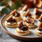 Goat Cheese & Fig Jam Canapés 3 Small round canapés topped with goat cheese, fig jam, and fig wedges arranged neatly on a plate.