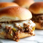 philly cheesesteak sloppy joe on a soft bun with melted provolone and peppers on a marble surface