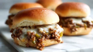 philly cheesesteak sloppy joe on a soft bun with melted provolone and peppers on a marble surface