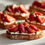 toasted crostini with whipped cheese and balsamic strawberries arranged on a bright surface with soft shadows