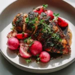 Balsamic Chicken with Roasted Radishes 3 Sliced balsamic chicken with roasted radishes on a plate, topped with fresh thyme and pan sauce.