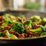 skillet of honey garlic ground beef and broccoli cooking together with glossy sauce and bright green florets